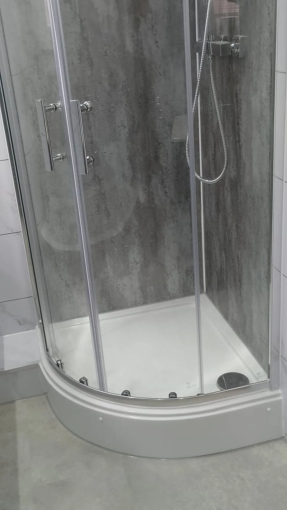 Curved glass shower enclosure with chrome fittings